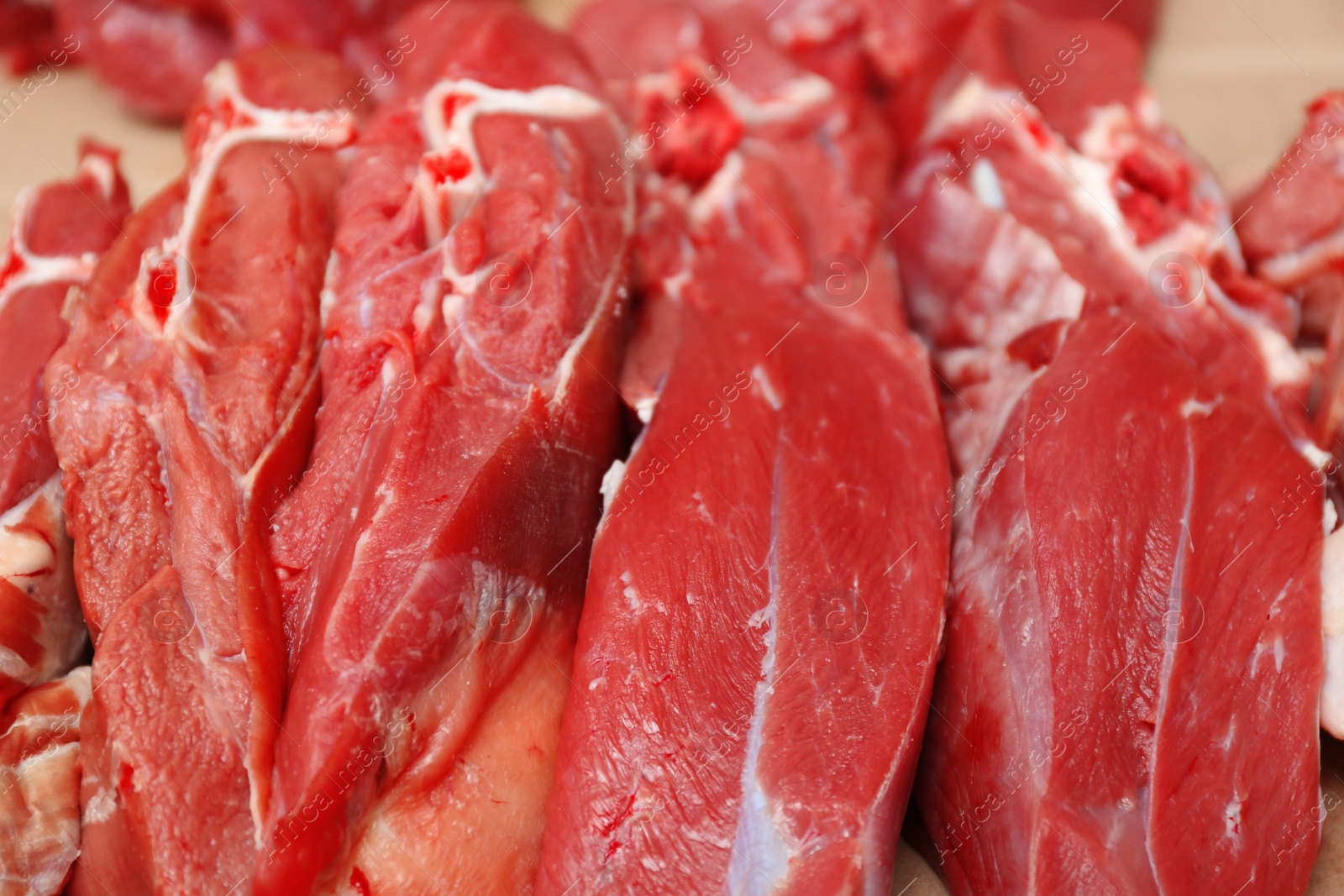 Photo of Pieces of fresh raw meat on counter in butcher shop