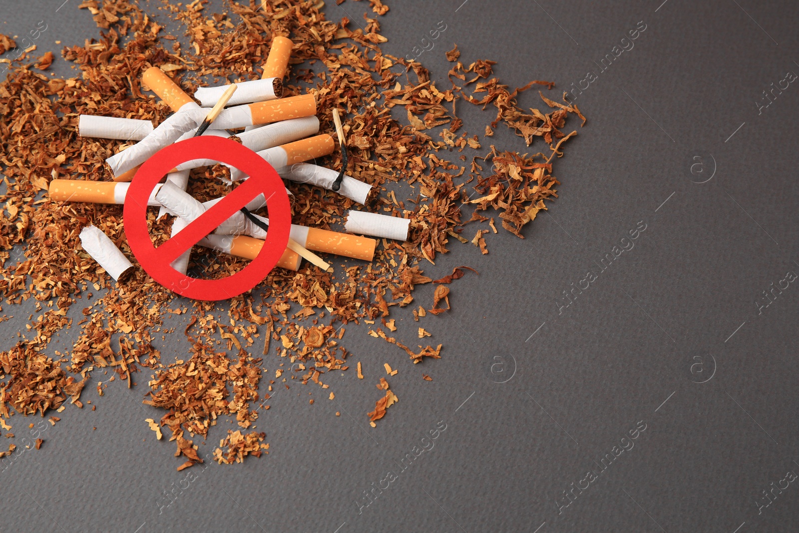 Photo of Prohibition sign, broken cigarettes and burnt matches on dark grey background, space for text. Quitting smoking concept