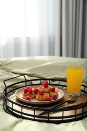 Tasty breakfast served in bedroom. Cottage cheese pancakes with fresh raspberries and juice on tray