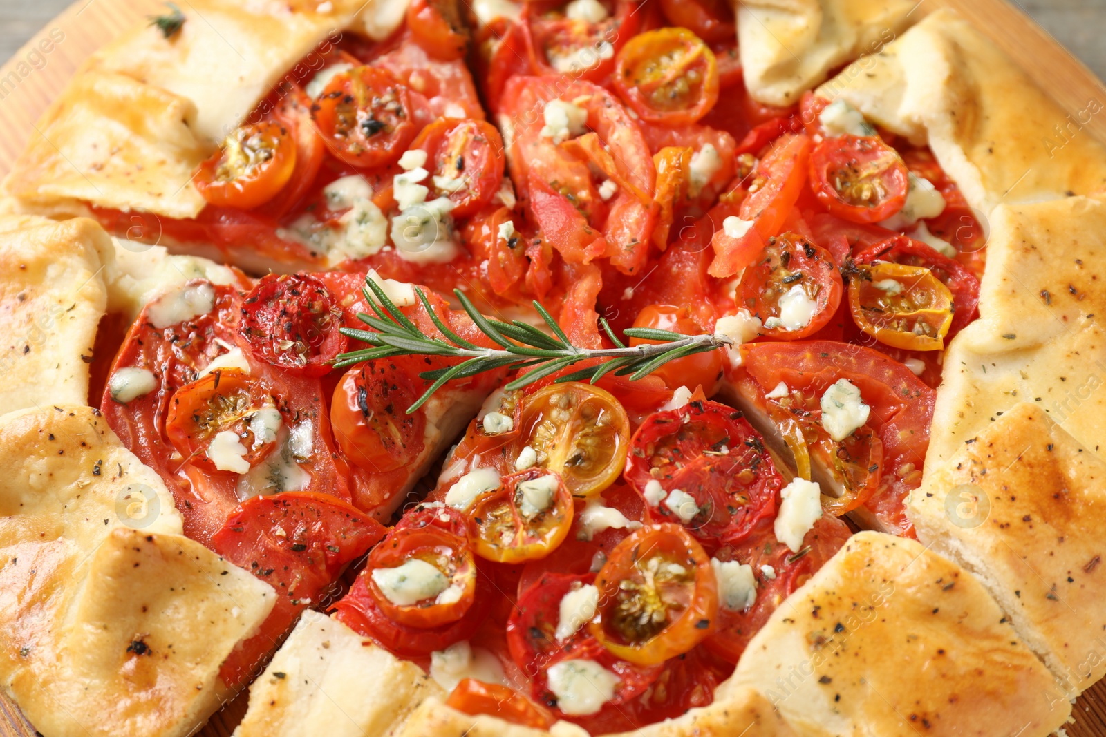 Photo of Tasty galette with tomato, rosemary and cheese (Caprese galette) as background, closeup