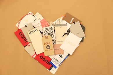 Photo of Leiden, Netherlands - December 6, 2023: Heart of different clothing tags on kraft paper sheet, top view