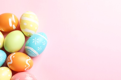 Photo of Many painted Easter eggs on color background, top view. Space for text