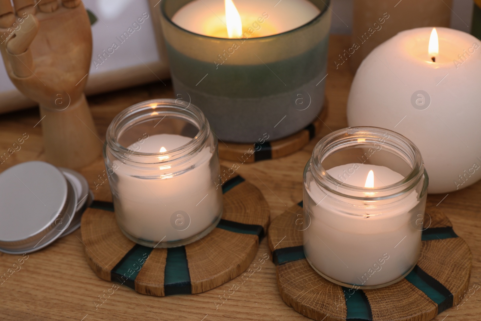 Photo of Many different burning candles on wooden table