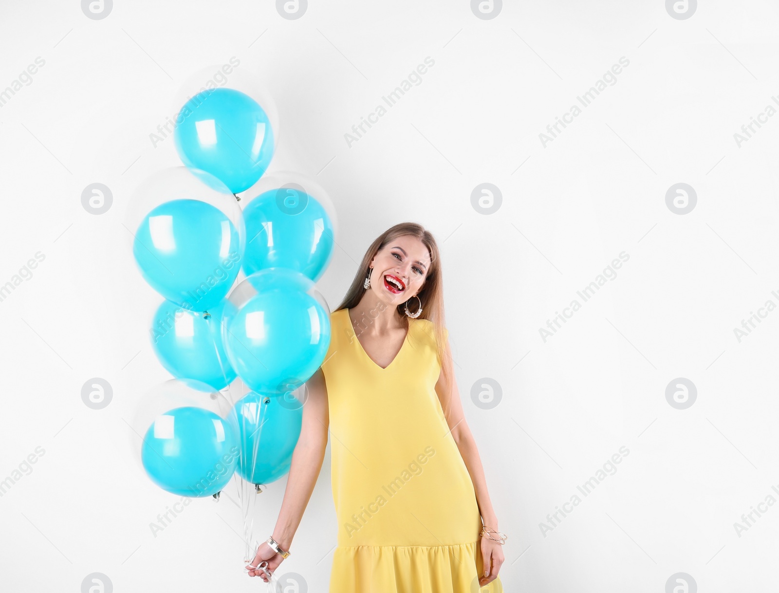 Photo of Young woman with air balloons on white background