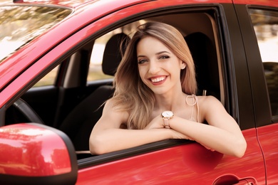 Photo of Happy young beautiful woman in modern car