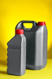 Photo of Canister and bottle of car products on yellow background