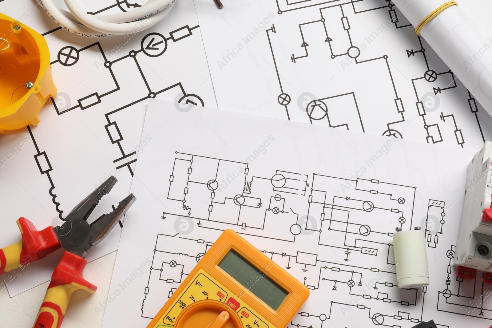 Photo of Wiring diagrams, different electrician's equipment and pliers on white table, flat lay