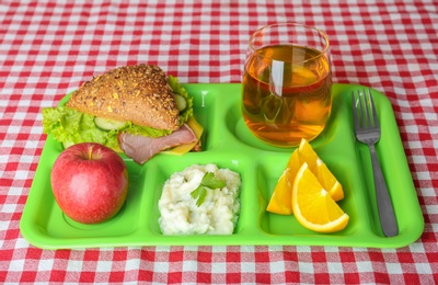 Photo of Serving tray with healthy food on table. School lunch