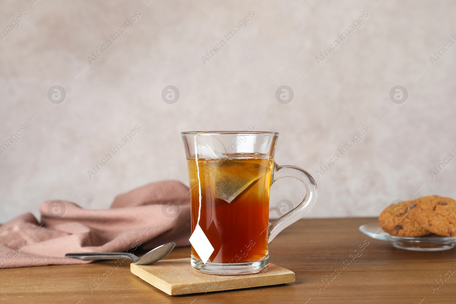 Photo of Cup of hot fresh tea on table against color background