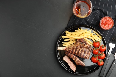 Image of Tasty grilled steak served on black table, flat lay. Space for text 