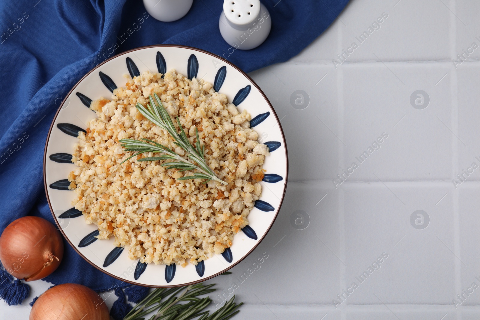 Photo of Fried ground meat in bowl and products on white tiled table, flat lay. Space for text