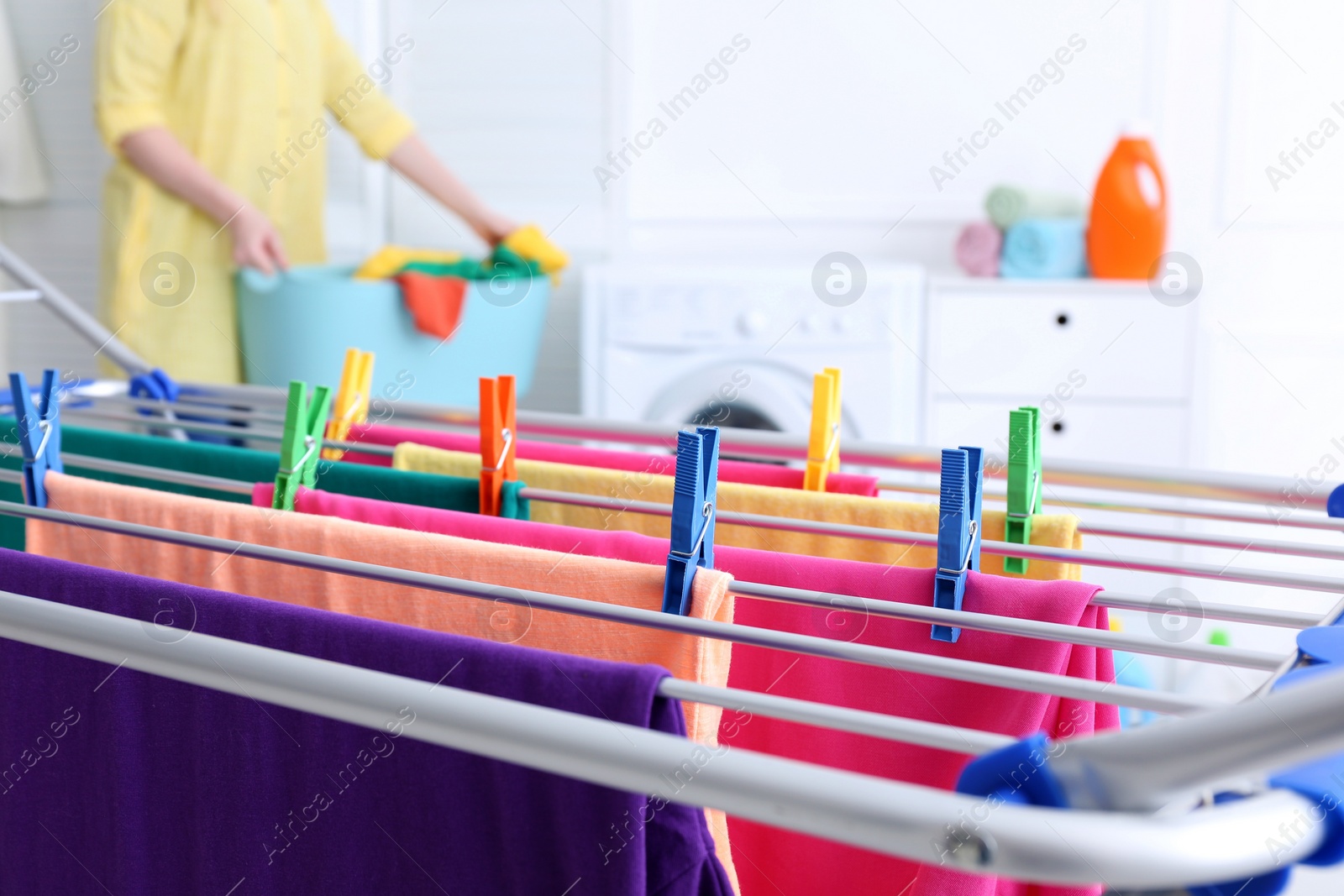 Photo of Clean laundry hanging on drying rack indoors, closeup