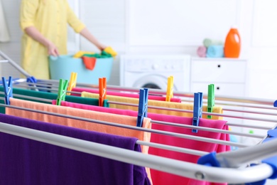 Photo of Clean laundry hanging on drying rack indoors, closeup