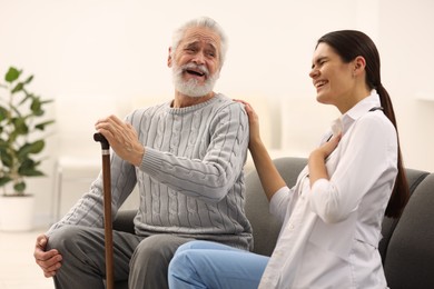 Photo of Health care and support. Nurse laughing with elderly patient in hospital