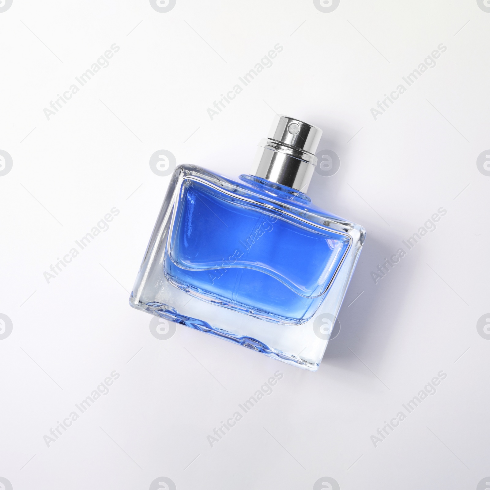 Photo of Blue men's perfume in bottle on white background, top view