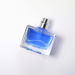 Photo of Blue men's perfume in bottle on white background, top view