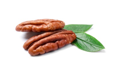 Tasty pecan nuts with green leaves isolated on white