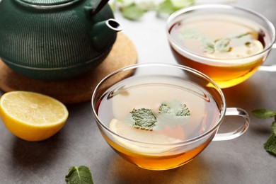 Aromatic herbal tea with mint and lemon on grey table