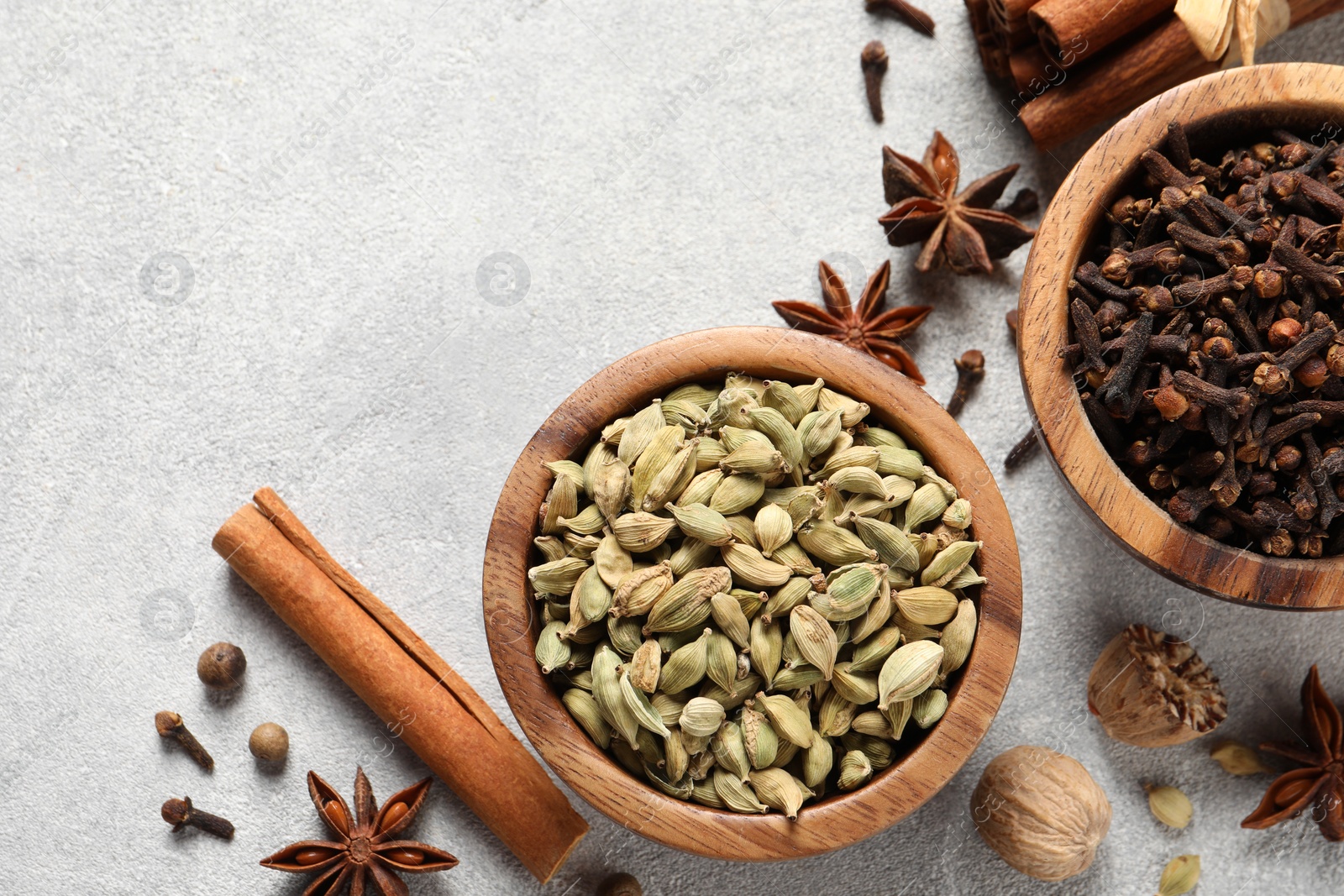 Photo of Different aromatic spices on light textured table, flat lay. Space for text