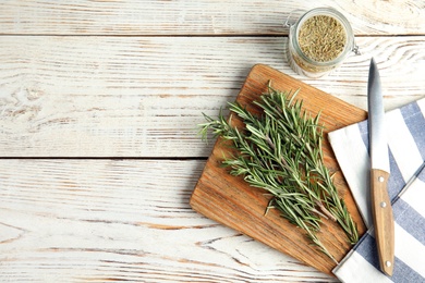 Photo of Flat lay composition with fresh rosemary twigs on wooden table. Space for text