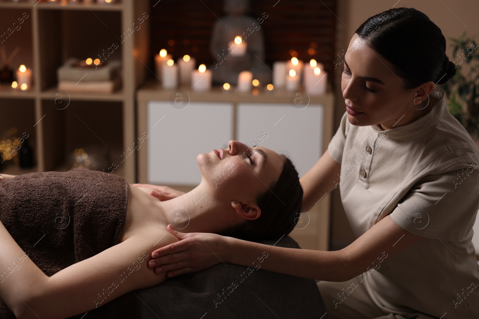 Photo of Spa therapy. Beautiful young woman lying on table during massage in salon