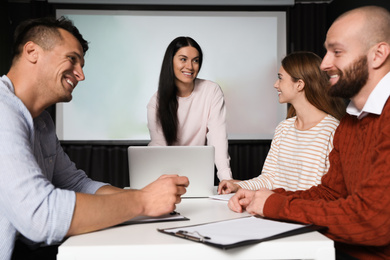 Photo of Business people having meeting in conference room with video projection screen