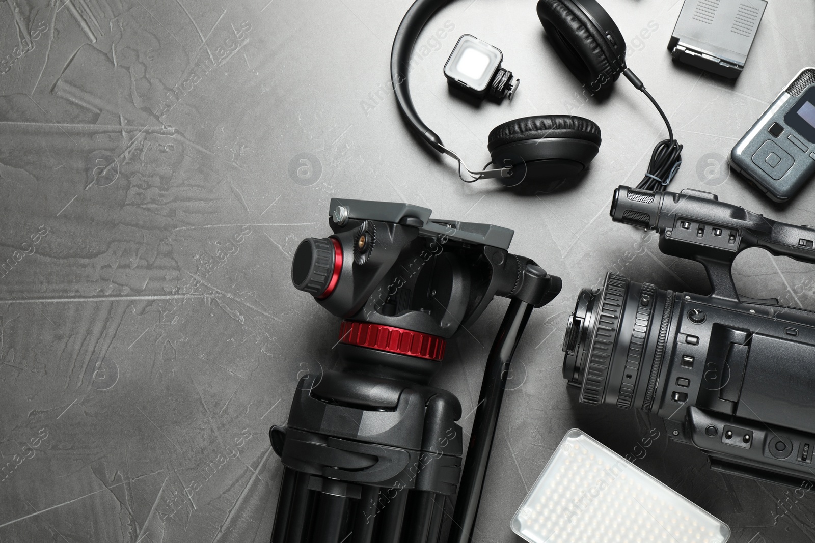 Photo of Flat lay composition with camera and video production equipment on grey stone background. Space for text