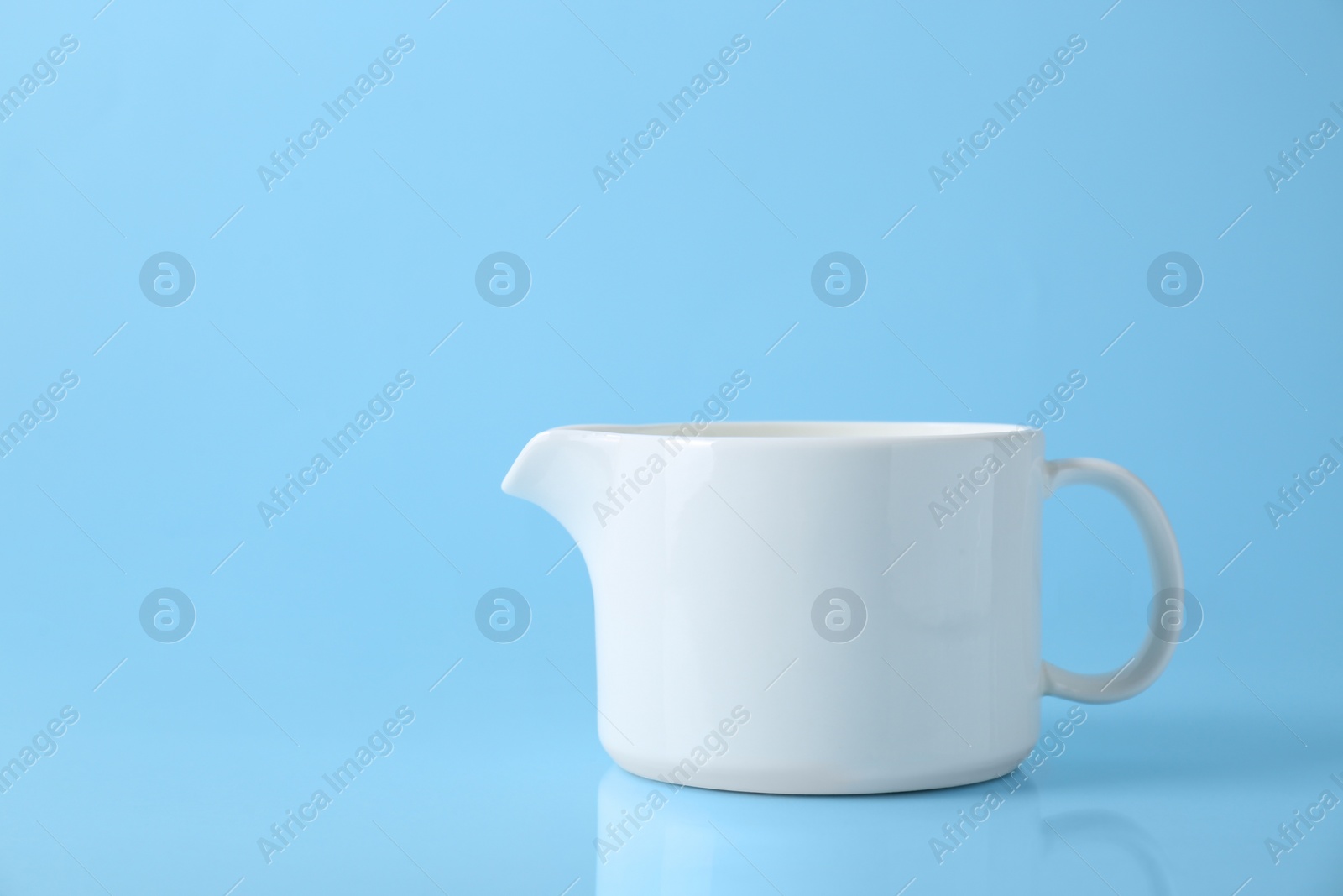 Photo of One jug on light blue background, space for text