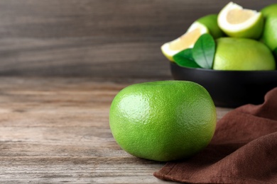 Fresh ripe sweetie fruit on wooden table, space for text