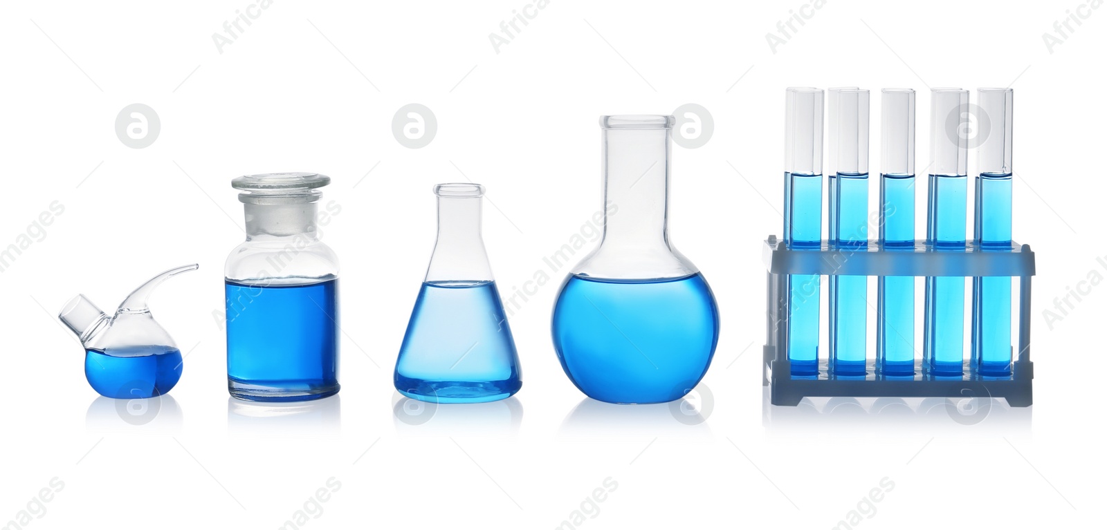 Photo of Set of laboratory glassware with blue liquid on white background