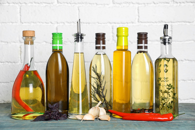 Photo of Different cooking oils on blue wooden table