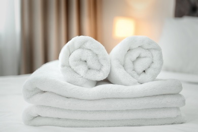 Photo of Clean towels on bed in modern hotel room