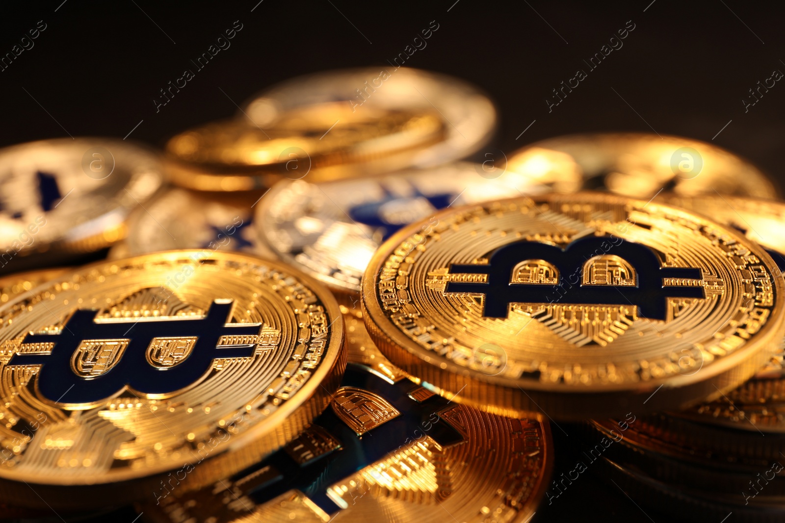 Photo of Shiny gold bitcoins on dark background, closeup view. Digital currency