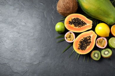 Photo of Fresh ripe papaya and other fruits on black table, flat lay. Space for text