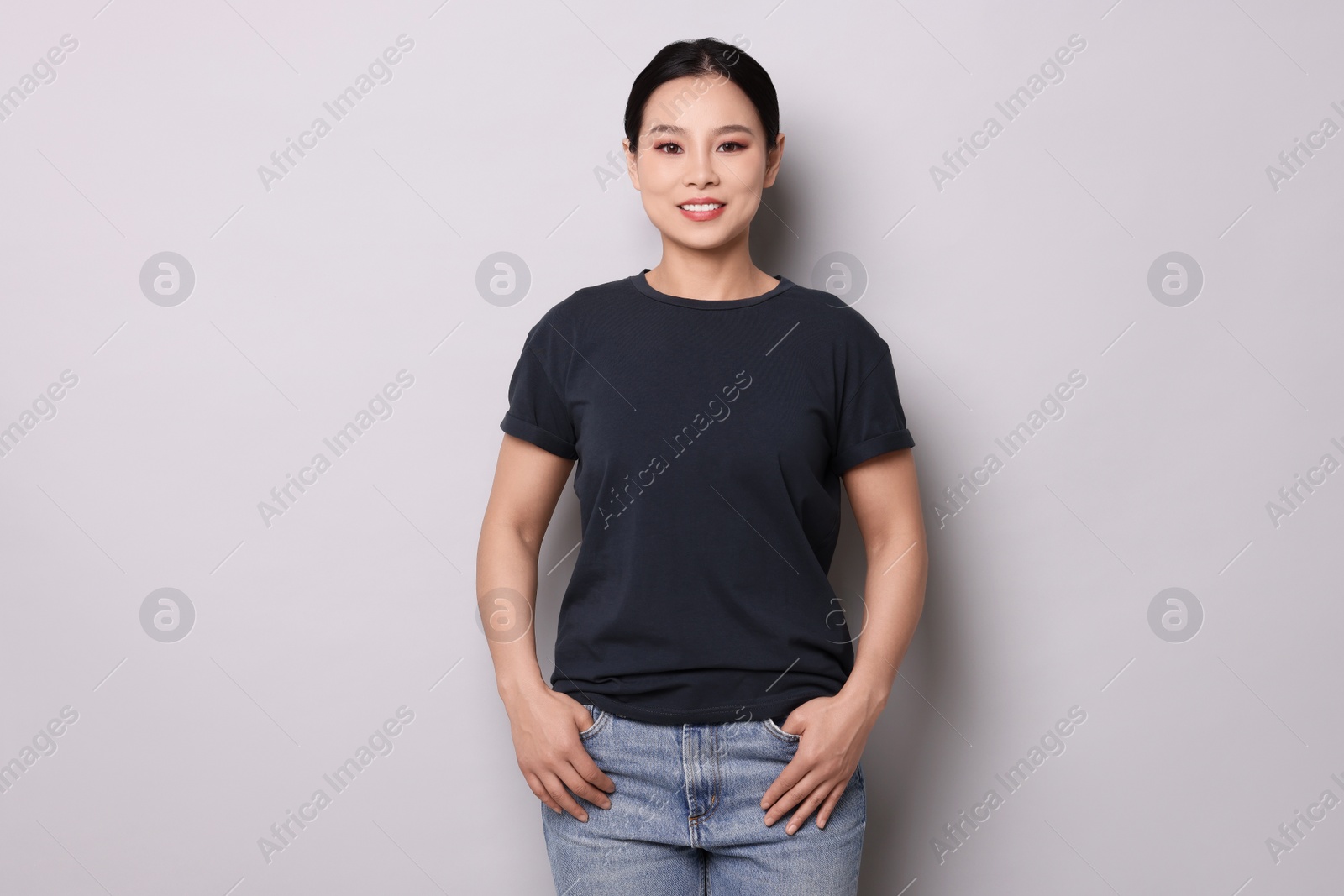 Photo of Woman wearing black t-shirt on light grey background