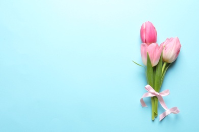 Photo of Beautiful spring tulips on color background, top view with space for text. International Women's Day