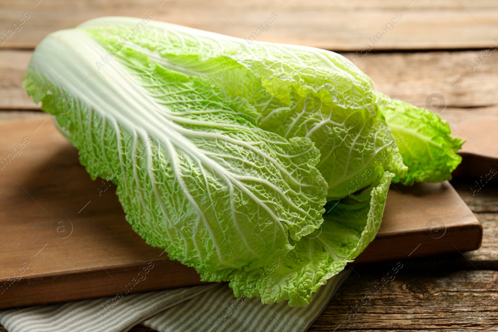 Photo of Fresh ripe Chinese cabbage on wooden table, closeup