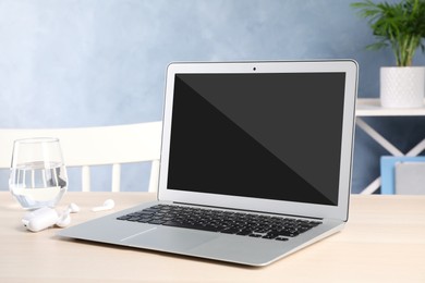 Image of Modern laptop on white table indoors. Comfortable workplace 