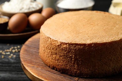 Delicious fresh homemade cake on board at black wooden table, closeup