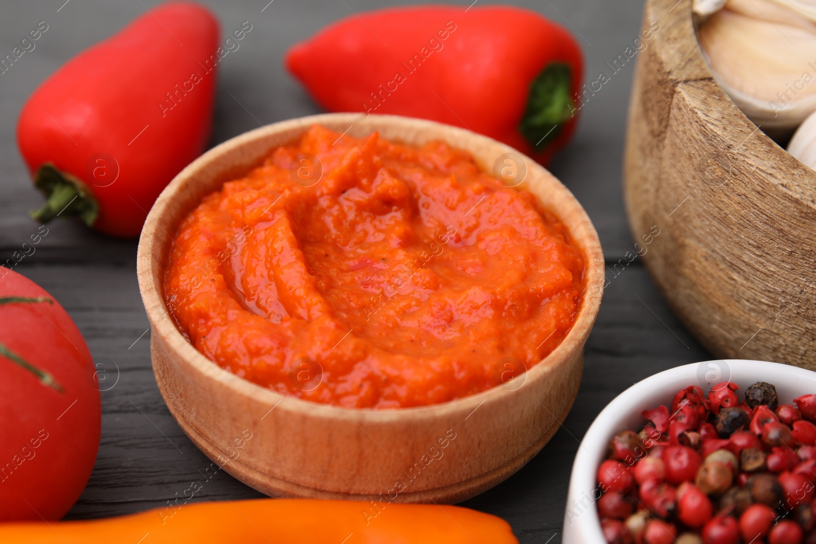 Photo of Fresh marinade in bowl and ingredients on grey wooden table, closeup