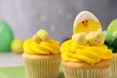 Photo of Tasty cupcakes with Easter decor on table, closeup