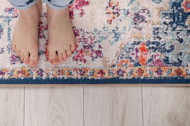 Photo of Woman standing on carpet with pattern, top view. Space for text