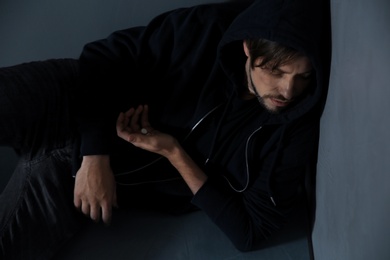 Photo of Passed out junkie after using drugs near grey wall