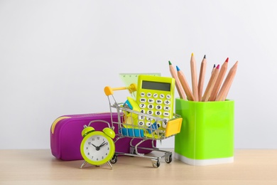 Different school stationery and alarm clock on table against white background. Back to school