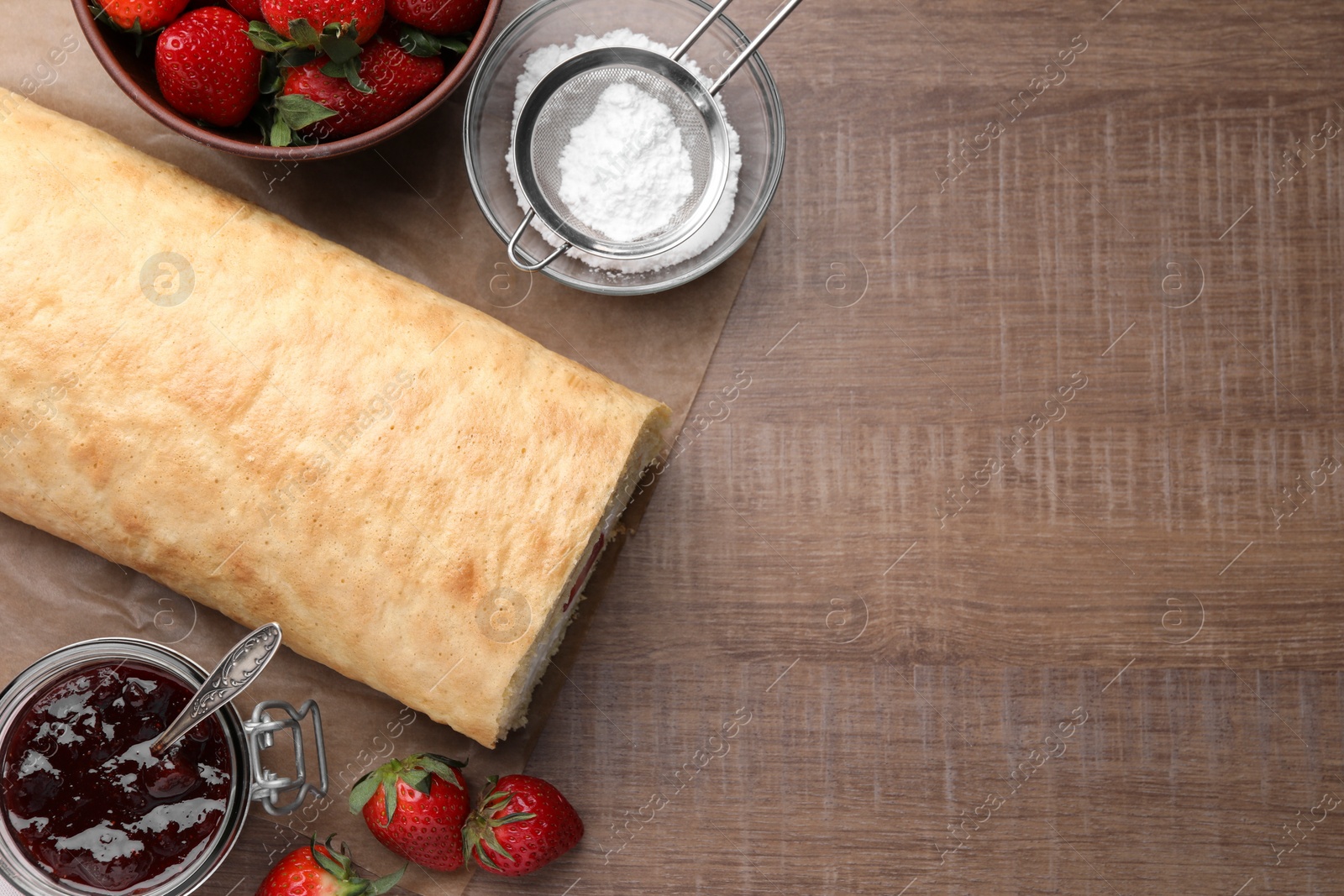 Photo of Delicious sponge cake roll with strawberries and cream on wooden table, flat lay. Space for text