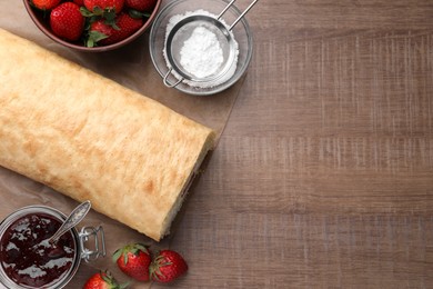 Delicious sponge cake roll with strawberries and cream on wooden table, flat lay. Space for text