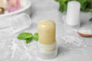 Photo of Natural crystal alum deodorant and mint on light grey marble table