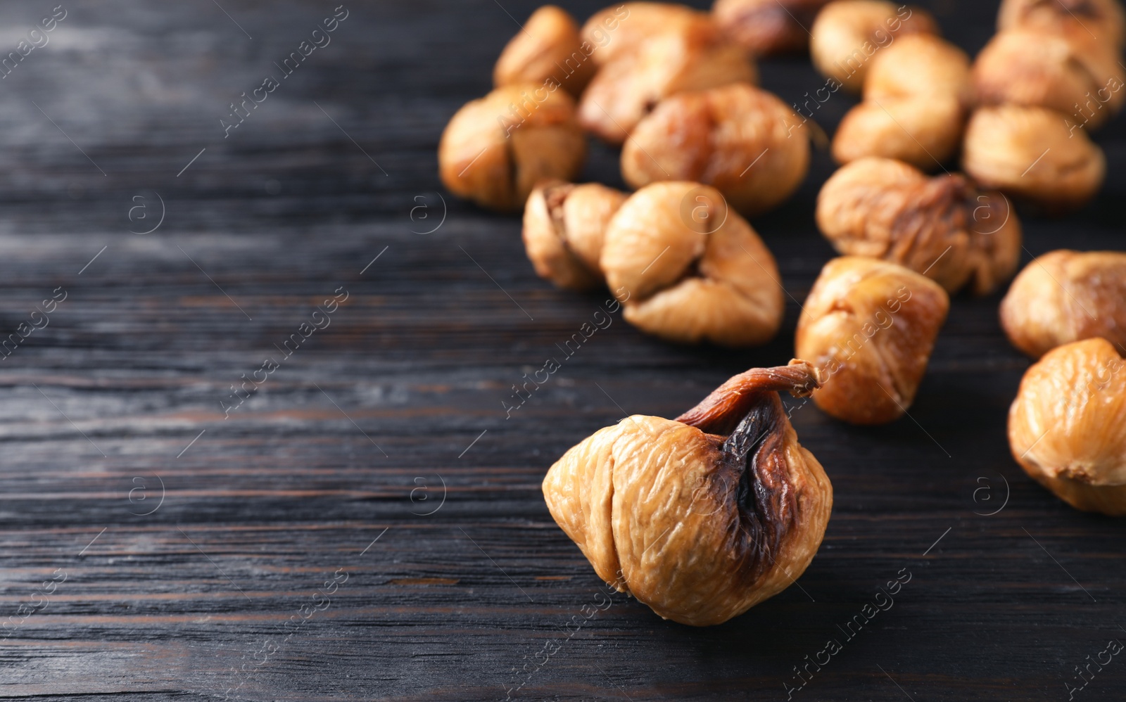 Photo of Delicious dried fig on wooden background, closeup. Space for text