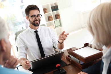 Male notary working with mature couple in office