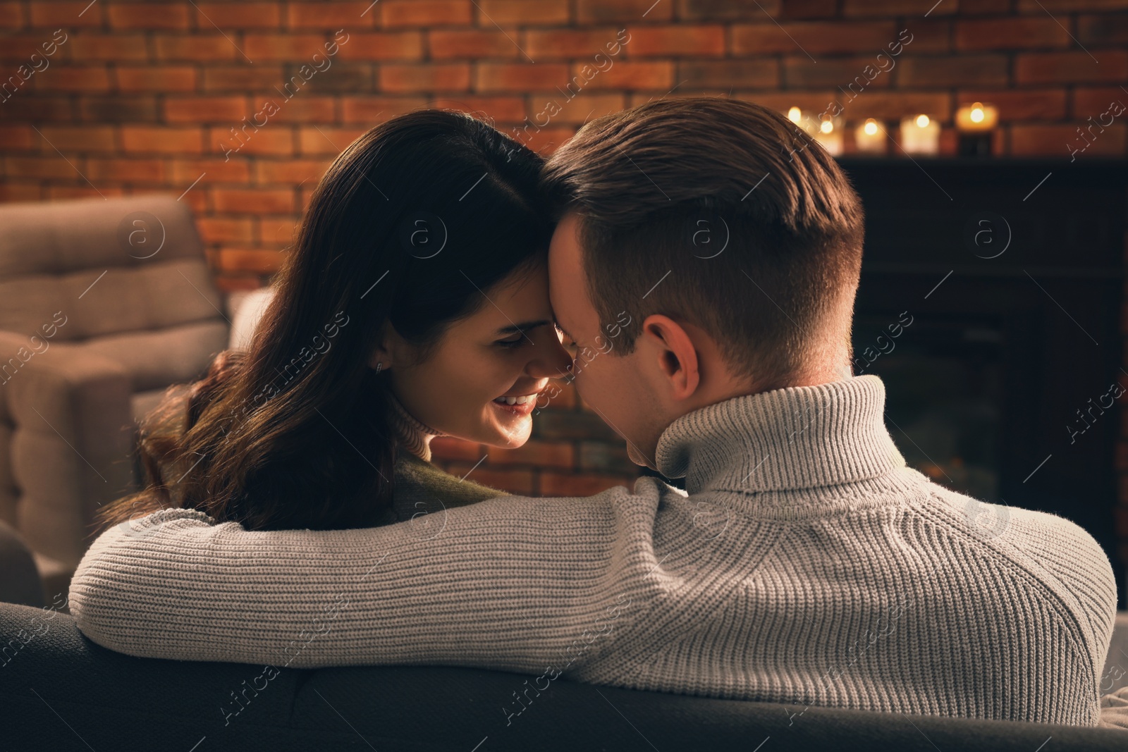 Photo of Lovely couple spending time together near fireplace at home